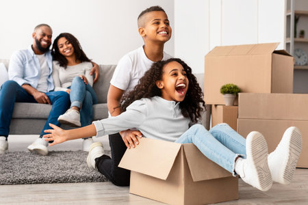 Happy African American family celebrating moving day in new apartmentの写真素材