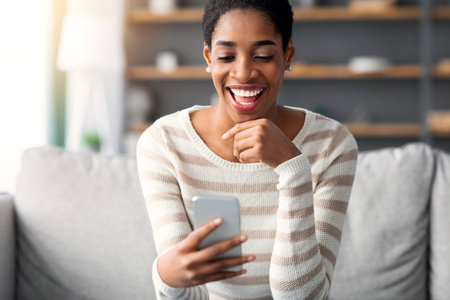 Online Dating App. Young Black Single Woman Using Smartphone At Homeの写真素材