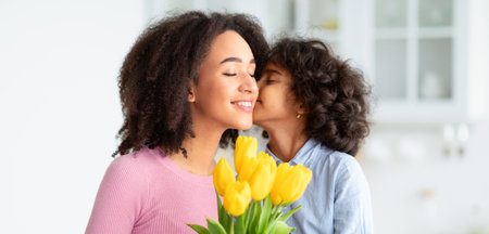 Black girl celebrating mothers day, greeting mum with flowersの写真素材