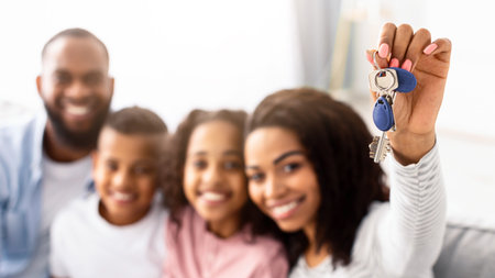 Happy African American family showing keys of their new apartmentの写真素材