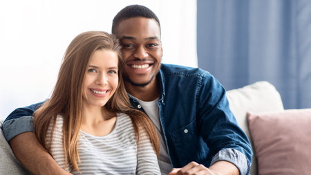 Portrait Of Smiling Young Multicultural Couple Posing In Home Interiorの写真素材