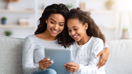 Happy african american mother and kid using digital tablet togetherの写真素材