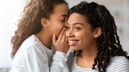 Black girl whispering something to her motherの写真素材