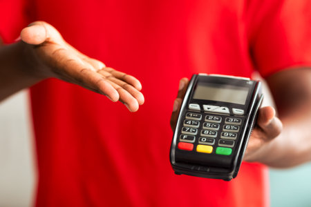 Closeup view of black man holding POS machine for payment