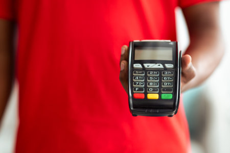 Cropped view of black man holding POS machine for payment