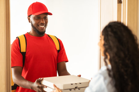 Black delivery man holding and giving pizza boxes