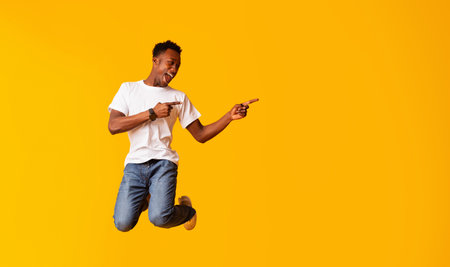 Excited emotional african man jumping over yellow background