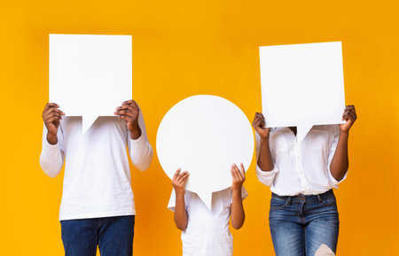 Black family of three covering faces with empty speech bubbles
