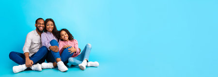Black husband hugging smiling lady and girl, sitting on floor