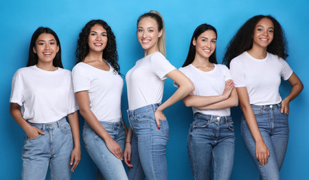 Pretty Multicultural Girls Smiling Standing On Blue Studio Background