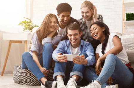 Guy showing video on phone to friends