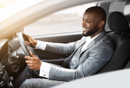 Cheerful african american businessman driving to work