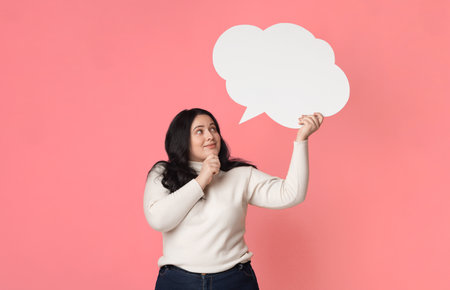 Pensive plump girl holding blank speech bubble over her head