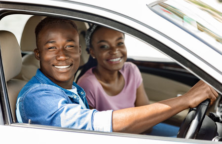 Beautiful afro american couple posing in their new auto