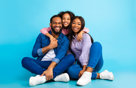 African American girl hugging her smiling mom and dad