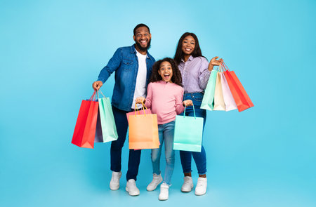 African American family of three posing with shopping bags