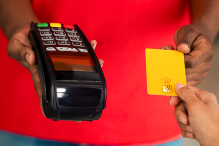 Cropped view of black man holding POS machine for payment