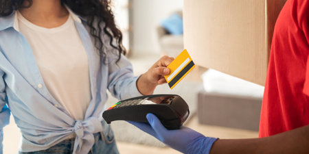 Black man holding POS machine lady paying with debit card