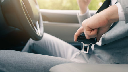 Male hand fastens seat belt in car. Buckle seat belt while sitting inside car before driving