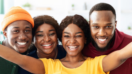 Positive black friends taking selfie while having fun together