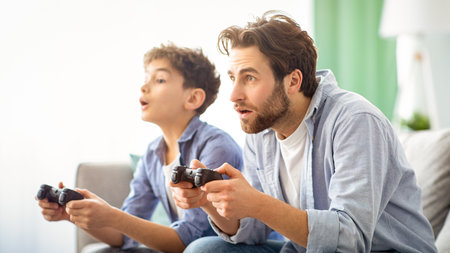 Leisure with dad. Concentrated father and son competing with each other in online video games, using...