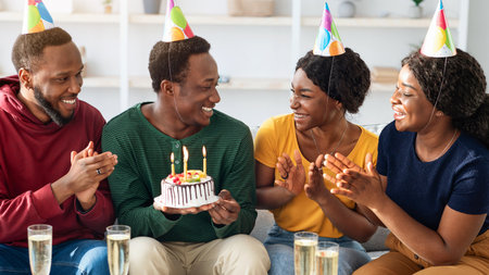 Group of happy black friends having birthday celebration at home