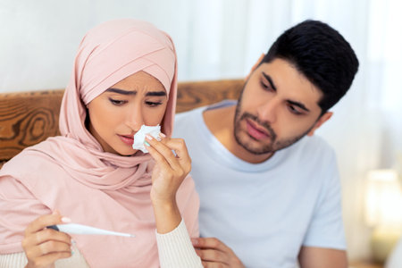 Illness during pregnancy. Loving muslim husband taking care about his sick pregnant wife, woman...