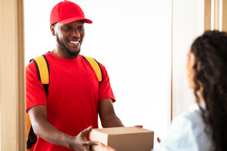 Black delivery man holding box giving it to customer