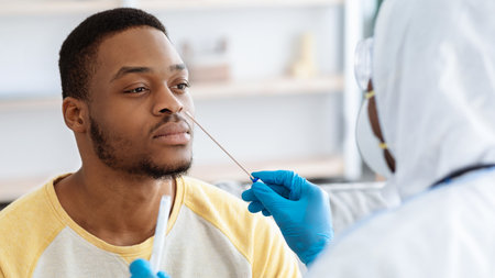 Black guy receiving nasal PCR test while staying homeの写真素材