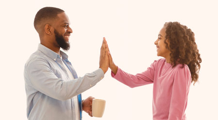 Dad and daughter giving high five in the kitchen