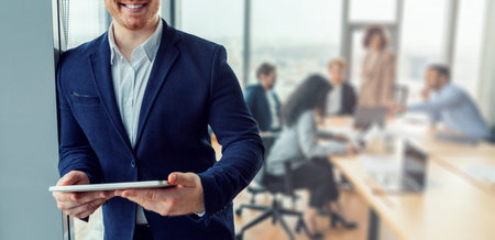 Confident Businessman Holding Tablet During Meeting in Modern Office