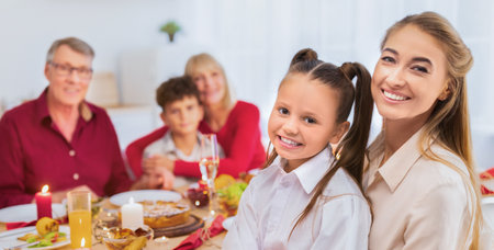 Portrait of happy multi generation family sitting at festive table, looking at camera and smiling