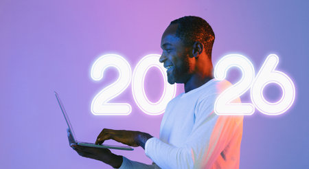 Happy Mature African American Man Typing on Computer in Vibrant Studio Setting