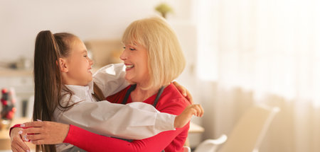 Cooking with granny. Adorable girl with grandmother hugging while preparing festive meal together in...