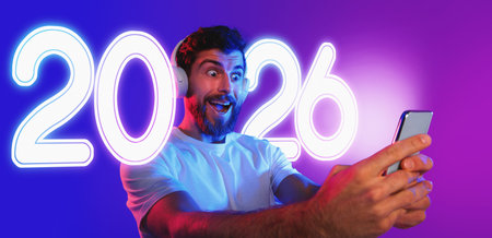 Surprised Guy With Headphones Enjoys Music on His Phone in Vibrant Studio Setting