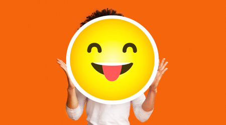 Black bushy man holding happy cheeky emoji emoticon in front of headの写真素材