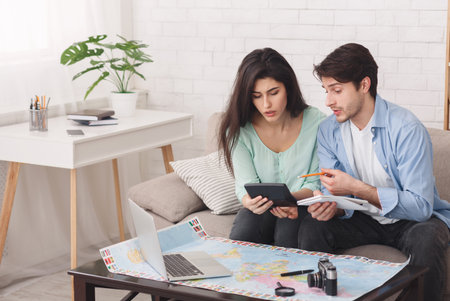 Couple counting finances for vacation, planning journeyの写真素材