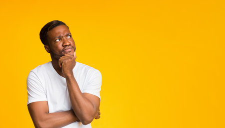 Afro Man Thinking Touching Chin Standing Over Yellow Background, Panoramaの写真素材
