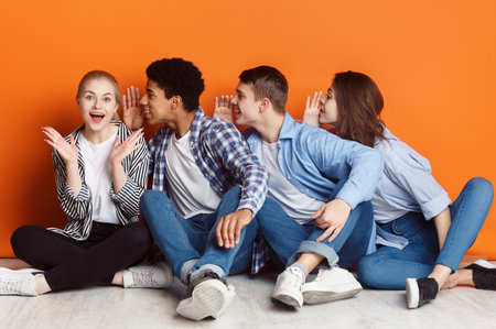 Group of friends whispering each other in the earの写真素材