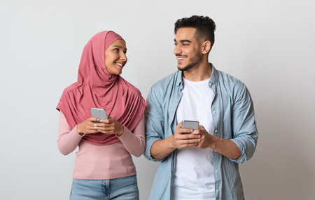 Portrait Of Happy Islamic Couple With Smartphones In Handsの写真素材