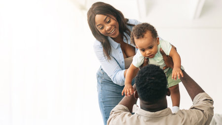 Happy African American family playing in new apartmentの写真素材