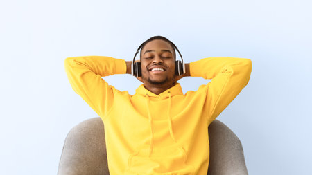 African American Guy Listening To Music Wearing Headphones, Gray Background