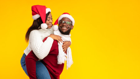 African American Husband Carrying Wife Piggyback On Christmas, Yellow Backgroundの写真素材