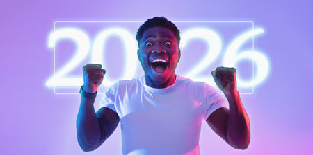 Young Man Celebrates Success With Joy in Vibrant Neon Lightsの写真素材