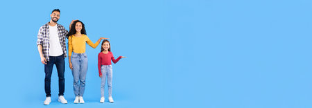 Middle Eastern Family Showing Each Others Height, Blue Backgroundの写真素材