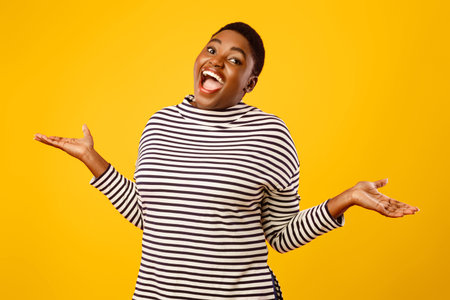 Cheerful Plump African American Lady Shrugging Shoulders Over Pink Backgroundの写真素材