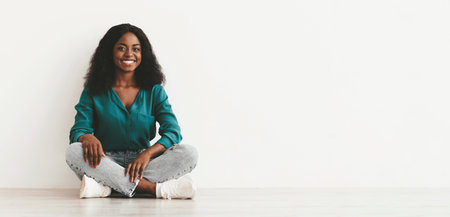 Positive pretty black lady posing over white backgroundの写真素材