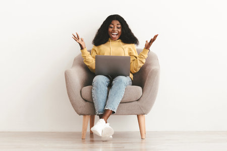 Emotional african american woman working on a laptopの写真素材