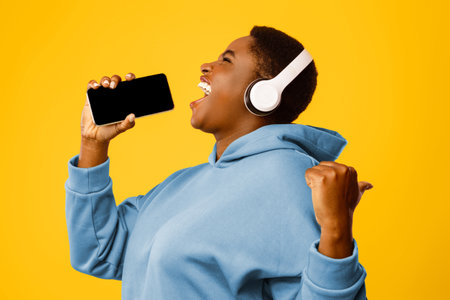 Overweight African Female Listening Music On Phone Singing, Pink Background