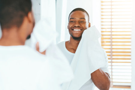 Daily Hygiene. Handsome Black Man Wiping Face With Towel In Bathroomの写真素材